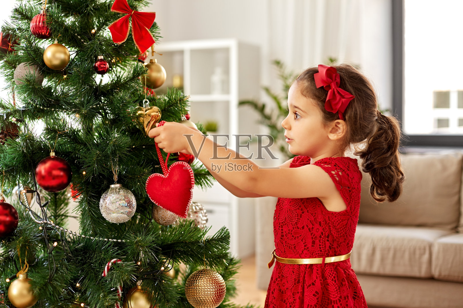 小女孩在家里装饰圣诞树照片摄影图片