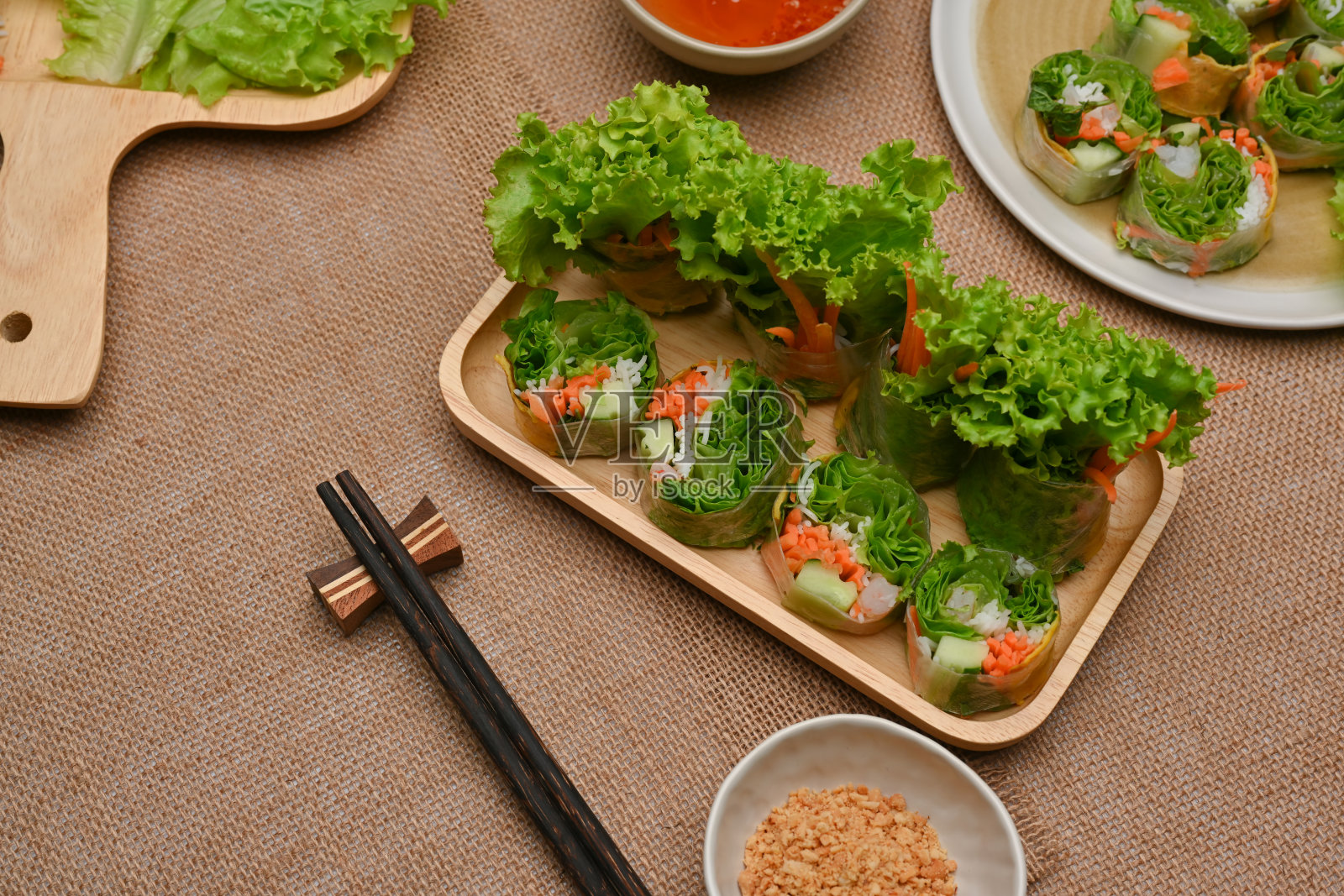 越南春卷蘸酱，用筷子夹在餐桌上照片摄影图片
