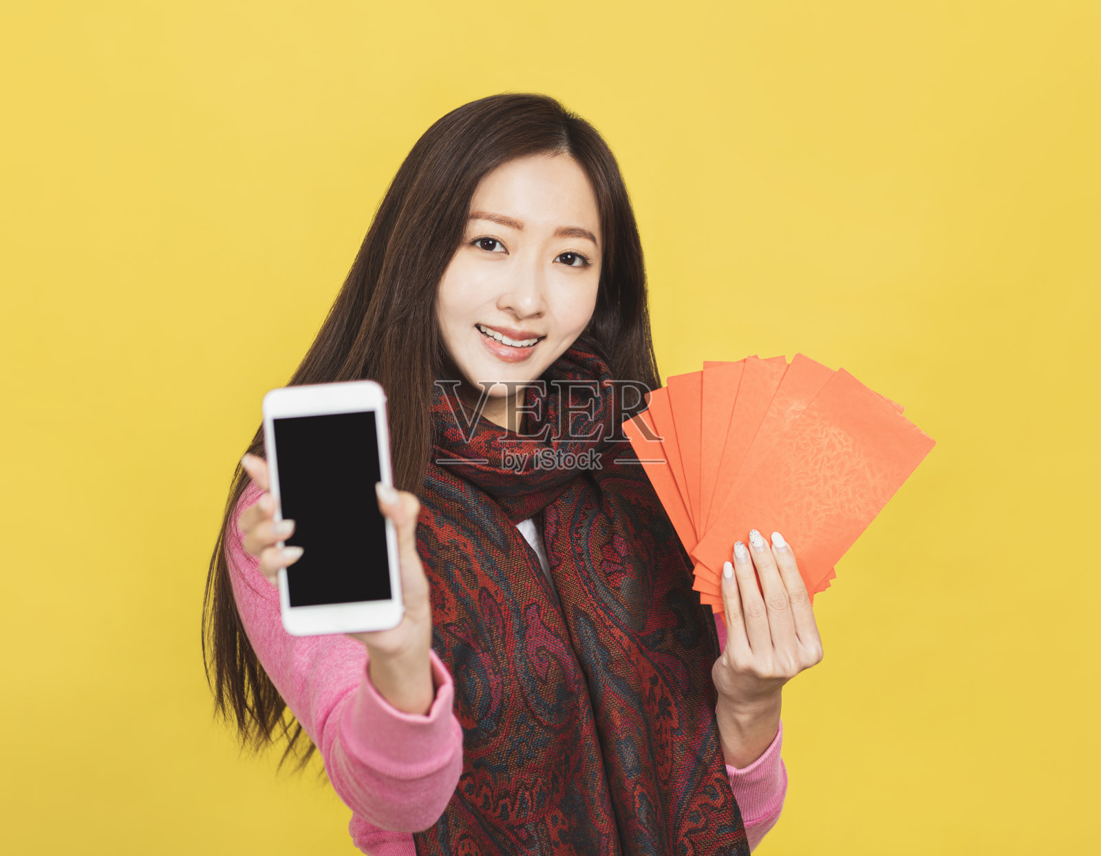 亚洲妇女展示红包和手机屏幕，庆祝中国新年的概念照片摄影图片