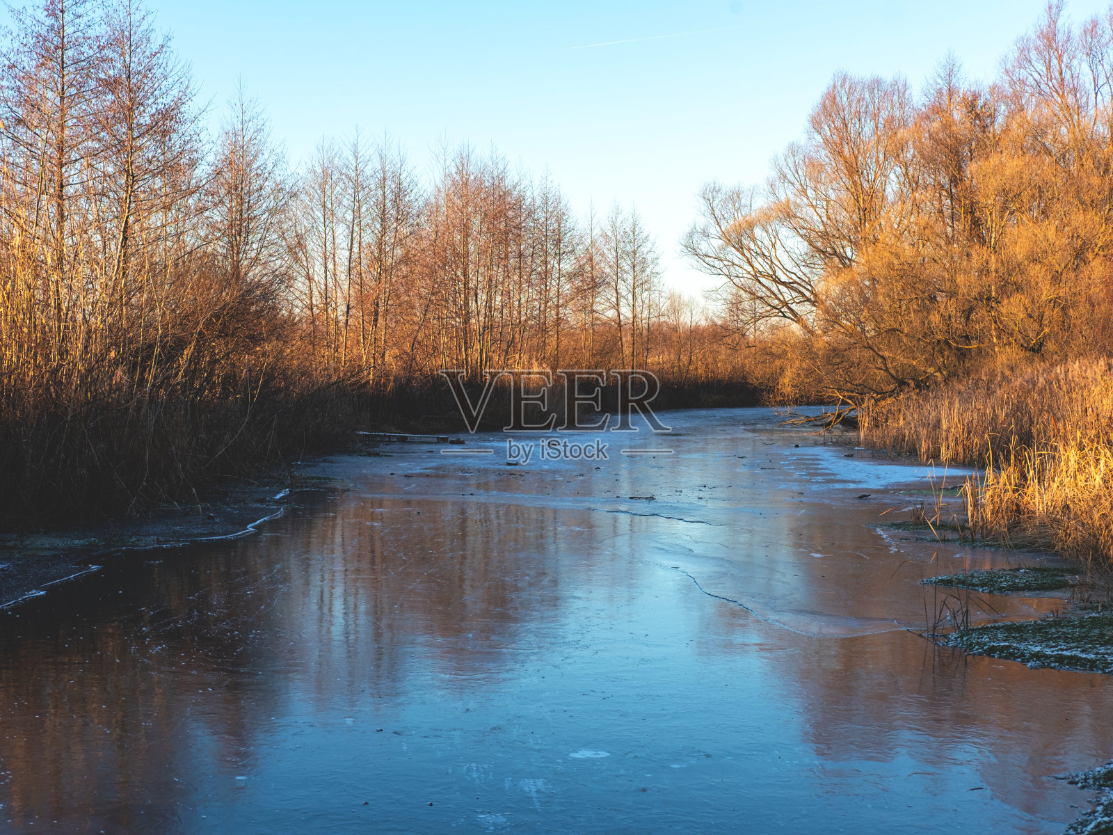 美丽的日落在冰冻的河作为美丽的冬季背景。有选择性的重点。照片摄影图片
