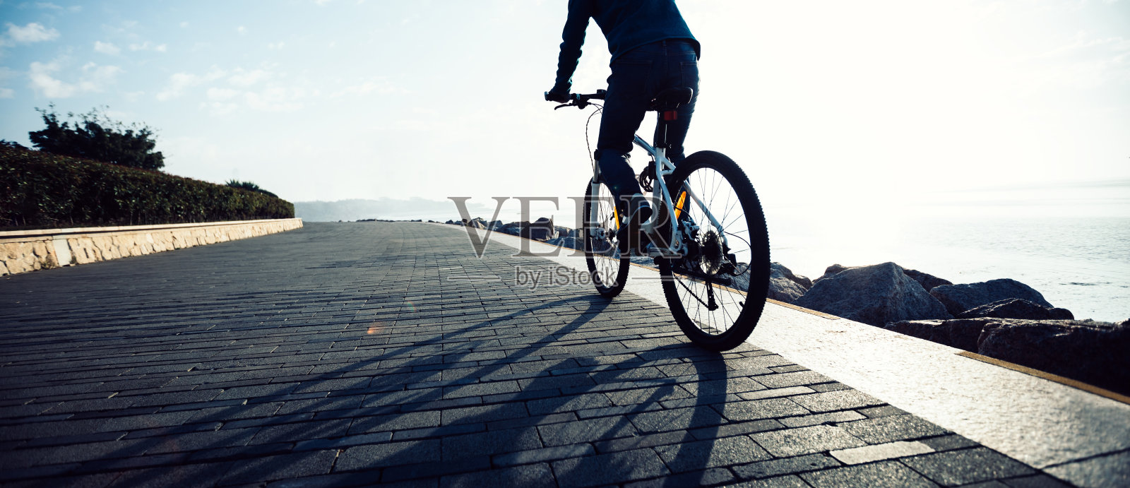 骑自行车的人在日出的海岸小径上骑自行车照片摄影图片