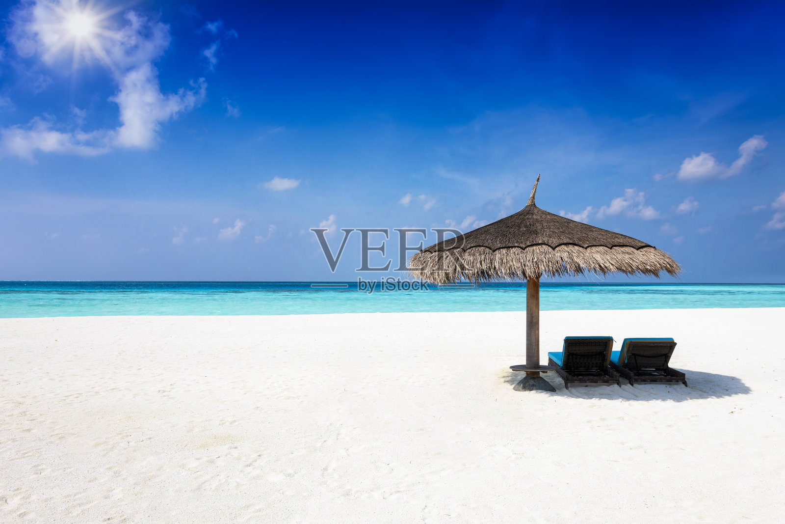 热带天堂般的海滩上，两张阳伞下的日光浴床照片摄影图片