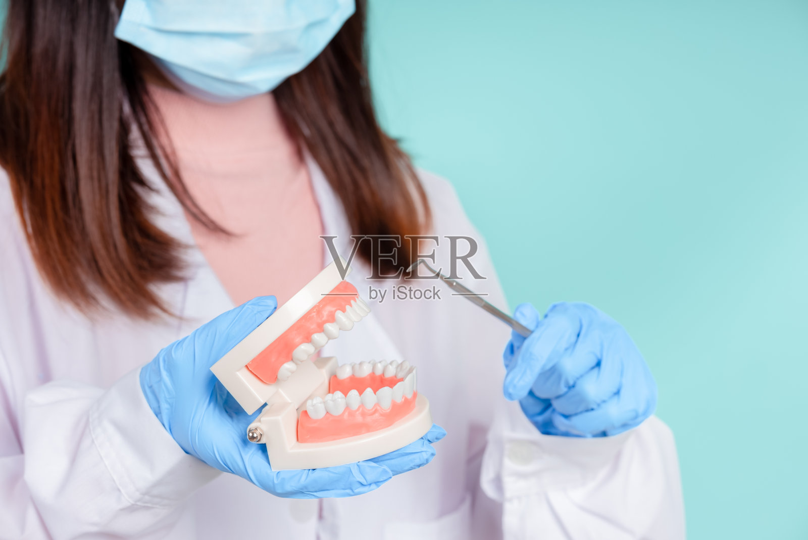 亚洲牙医正在教他们如何护理口腔和牙齿护理，包括正确的矫正治疗后，在蓝色背景孤立的工作室拍摄。照片摄影图片