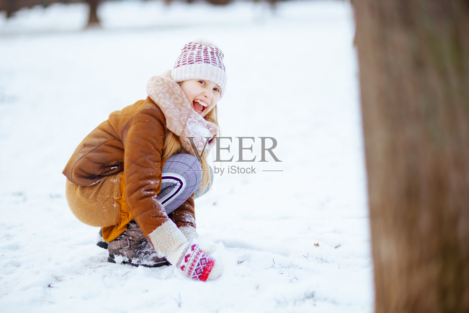 微笑的时尚的孩子在城市公园的冬天玩照片摄影图片