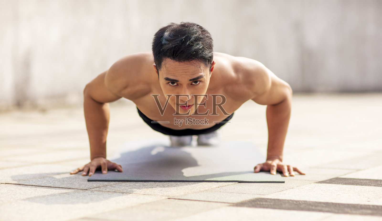 健身亚洲年轻帅哥做俯卧撑锻炼照片摄影图片