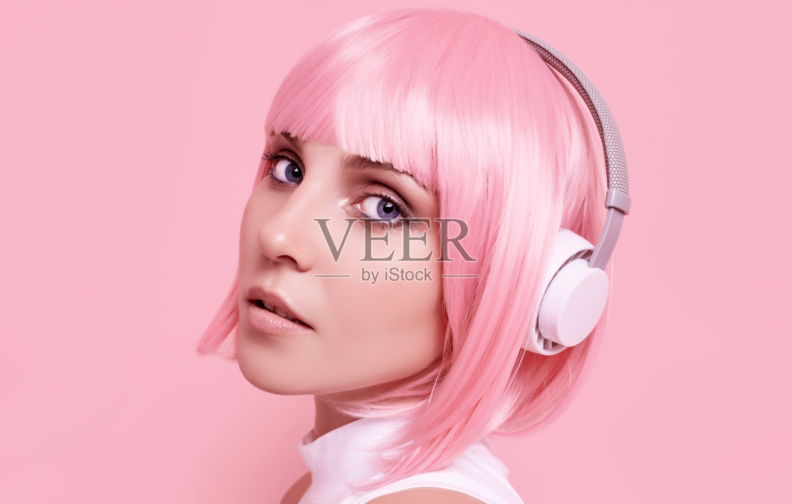 粉色头发的时髦女孩喜欢戴着耳机听音乐照片摄影图片