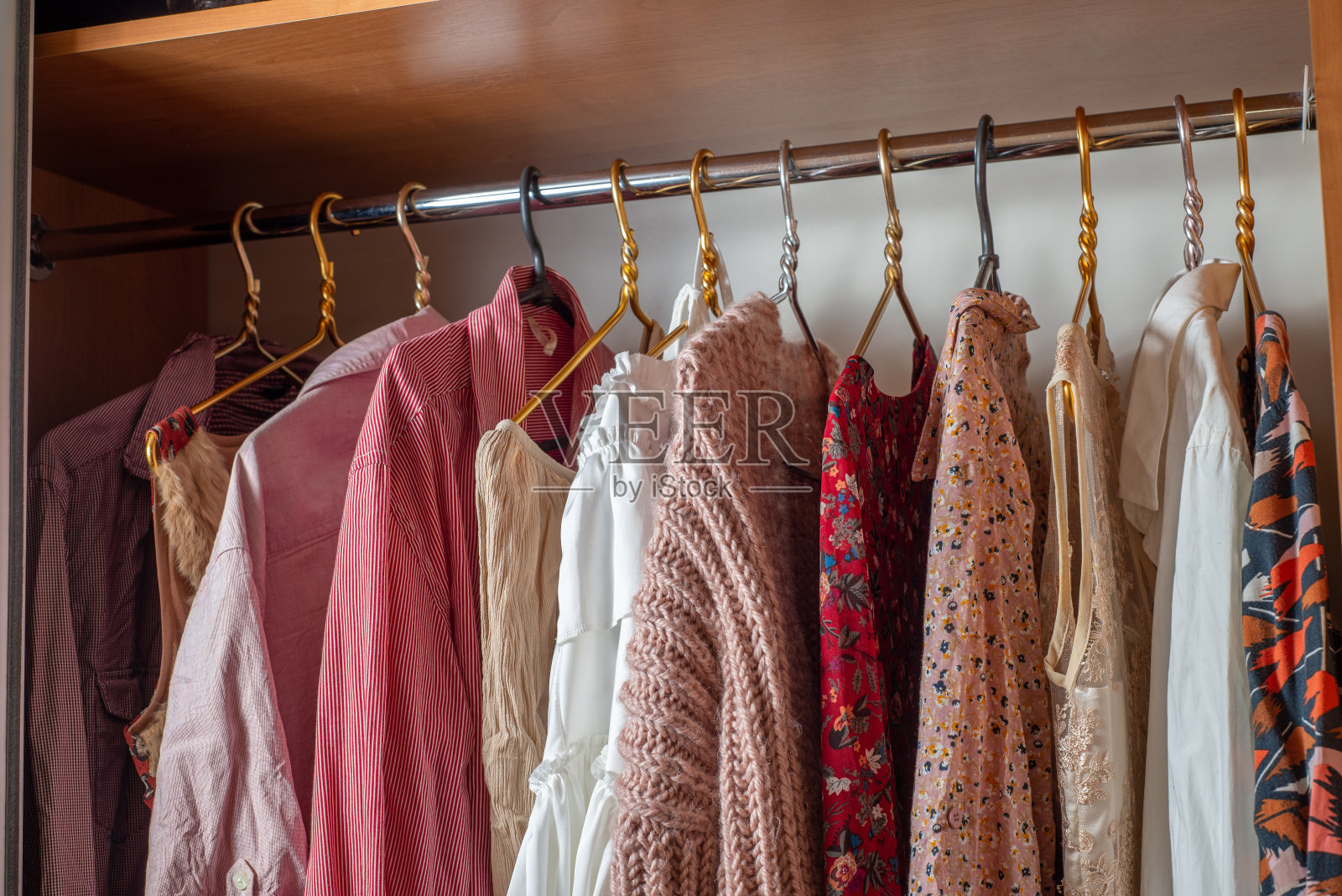 粉色的衣柜。衣柜里的衣架上挂着许多精致轻薄的夏装。
清理房间照片摄影图片