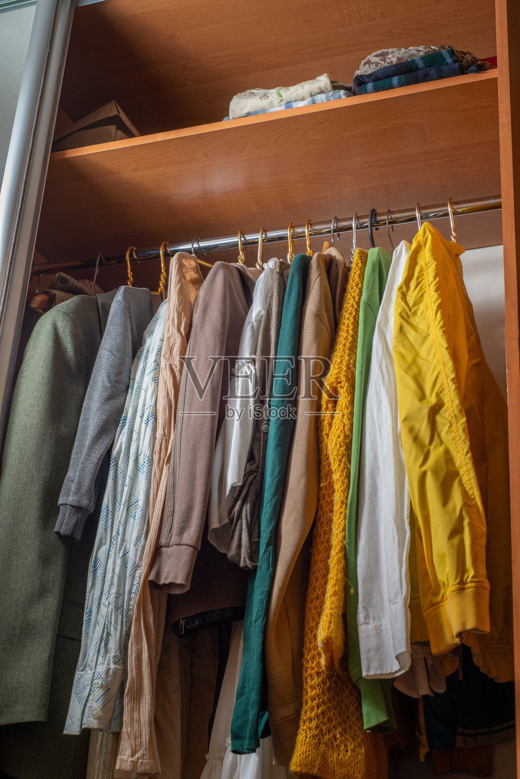 衣柜里有很多颜色鲜艳的衣服挂在衣架上。清除内阁。秒针照片摄影图片