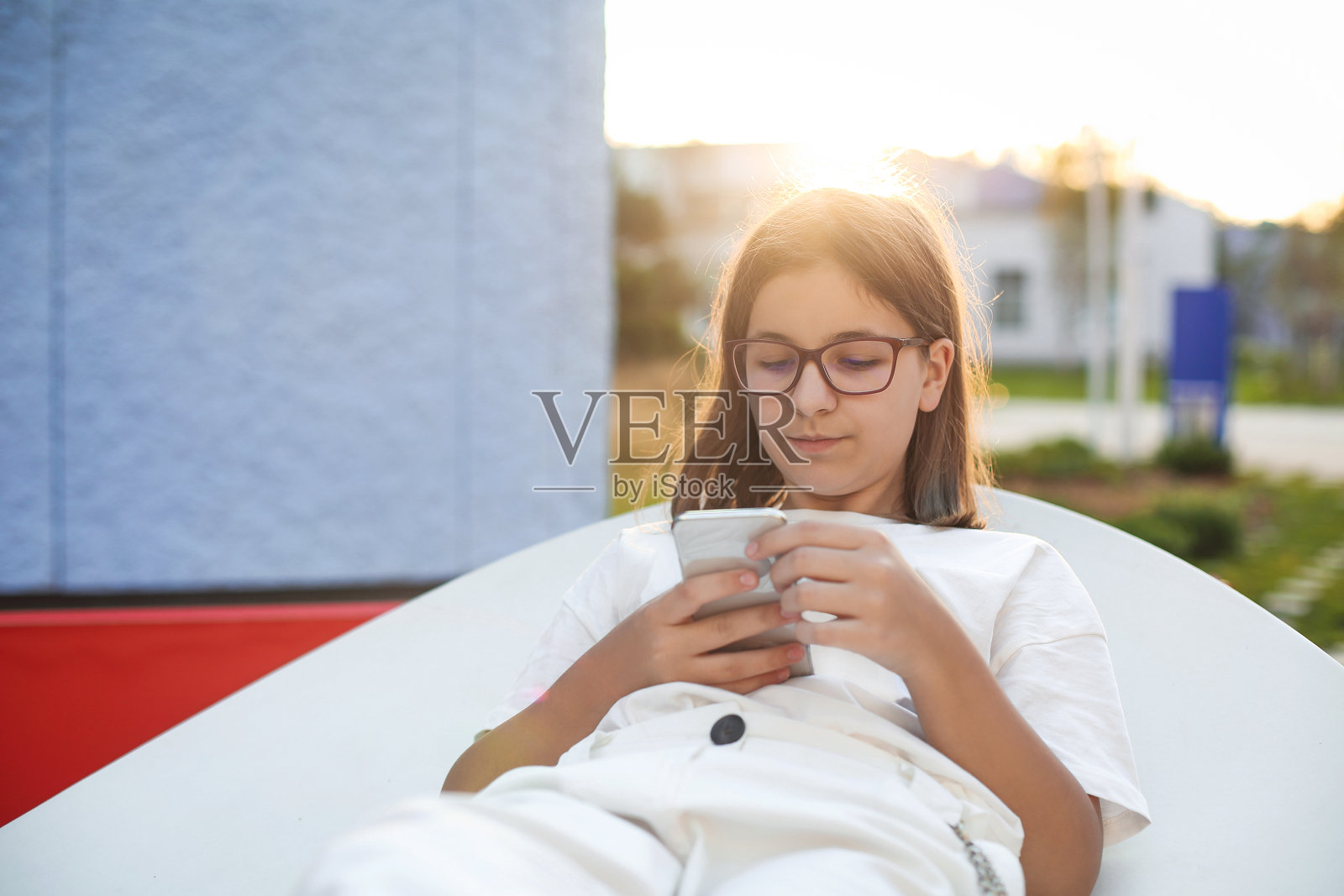 年轻时髦的少女在公园的长椅上使用智能手机照片摄影图片