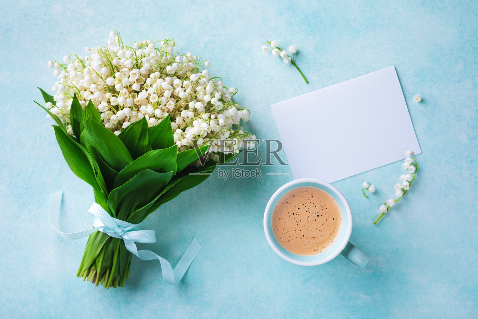 咖啡杯与春天的花束山谷百合和空贺卡俯视图。早上好，早餐的概念。照片摄影图片