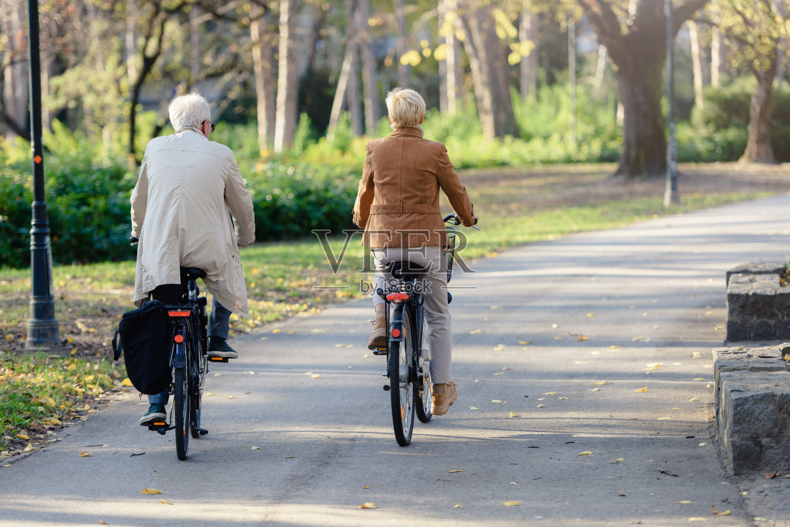 欢快活跃的老夫妇与自行车在公共公园一起玩照片摄影图片