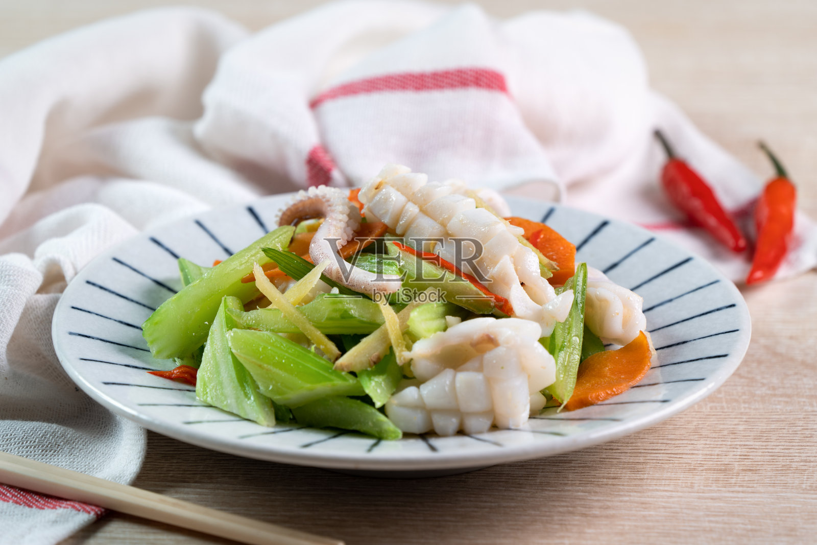 西芹炒浅海鱿鱼。美味的自制海鲜配蔬菜餐。照片摄影图片