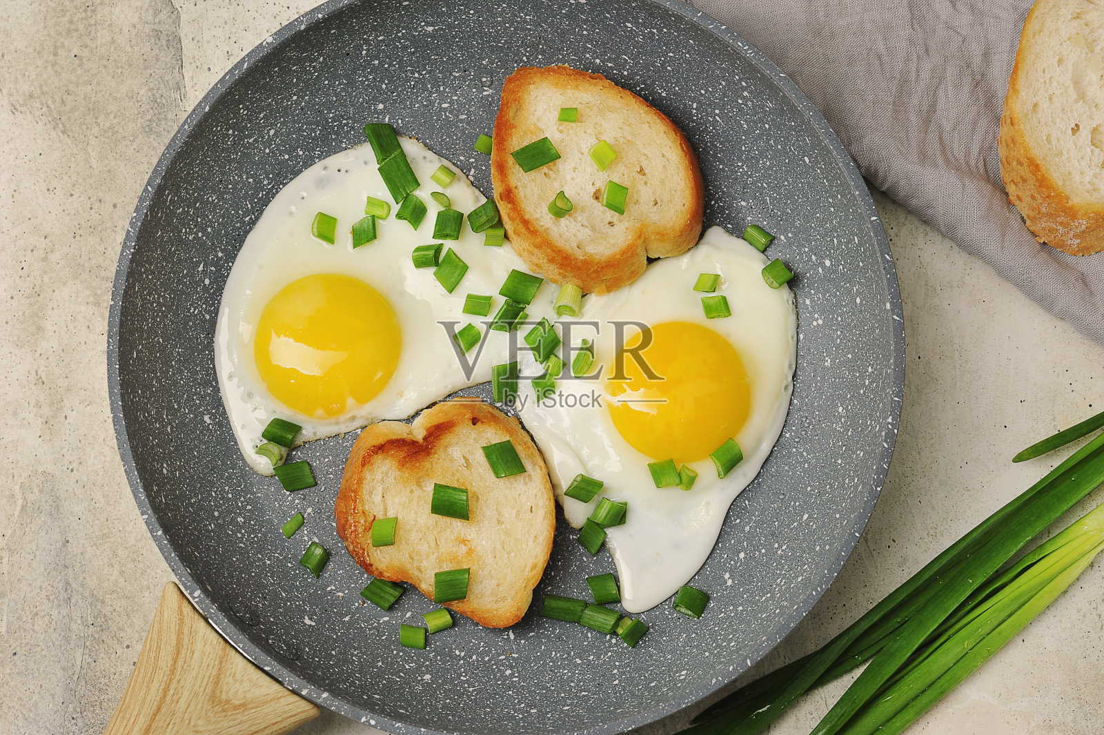 早餐有煎蛋，大葱和法式长棍面包照片摄影图片