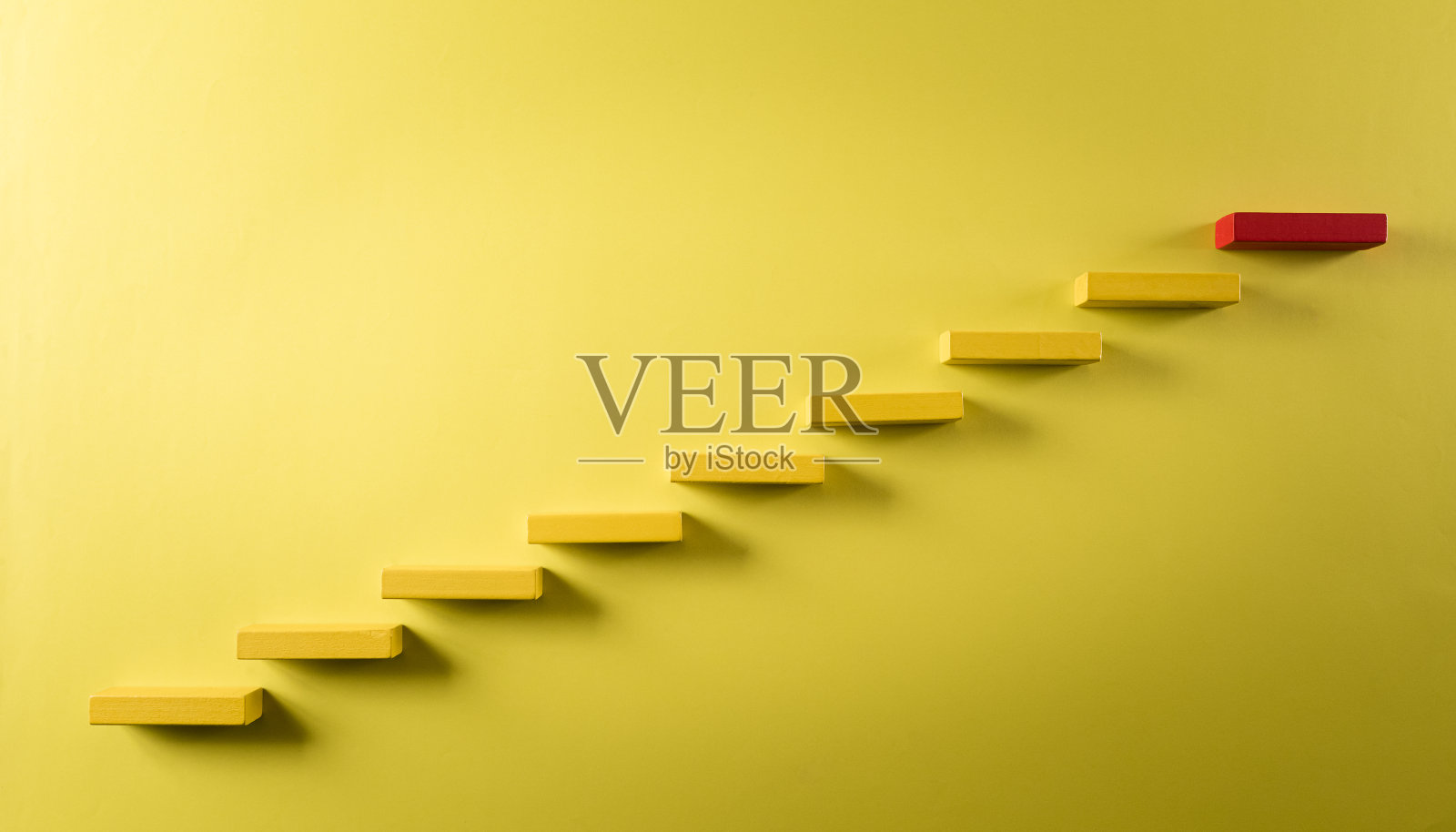 建立成功的理念基础。黄色和红色的木块堆叠为阶梯，成功的商业增长概念在柔和的背景。照片摄影图片