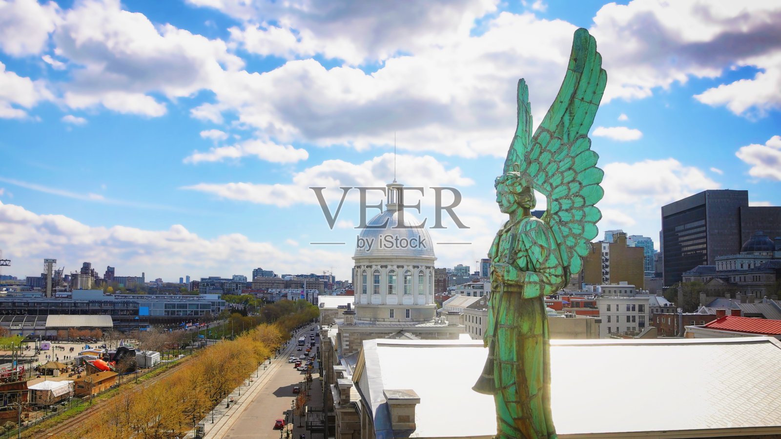 蒙特利尔市将老城的景色抬高，前景中有一尊19世纪的天使雕像照片摄影图片