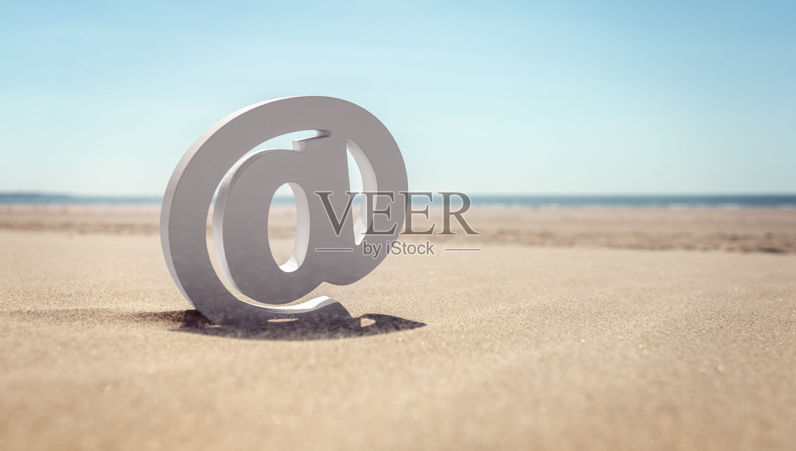 电子邮件符号在海滩上的沙子照片摄影图片