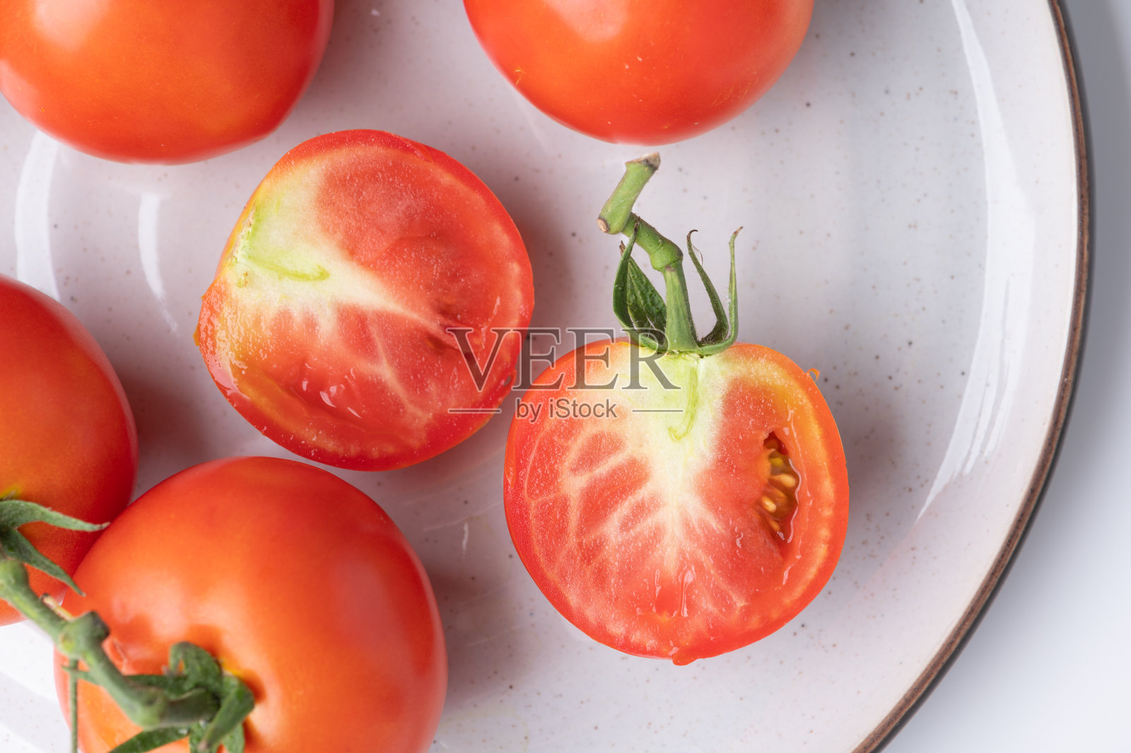新鲜的西红柿，绿色的茎，白色的背景照片摄影图片