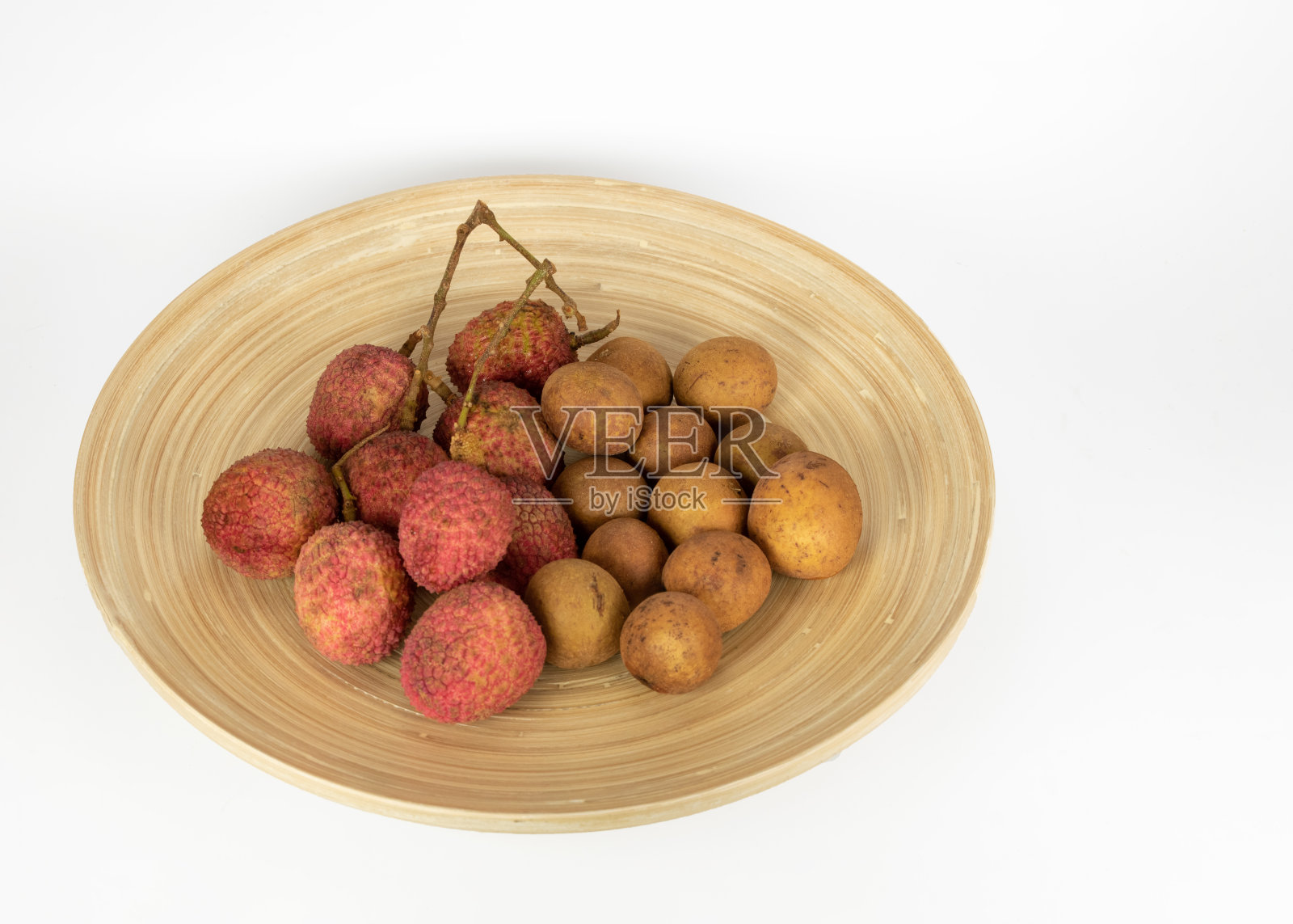 荔枝和龙眼水果在一个圆形木盘子照片摄影图片