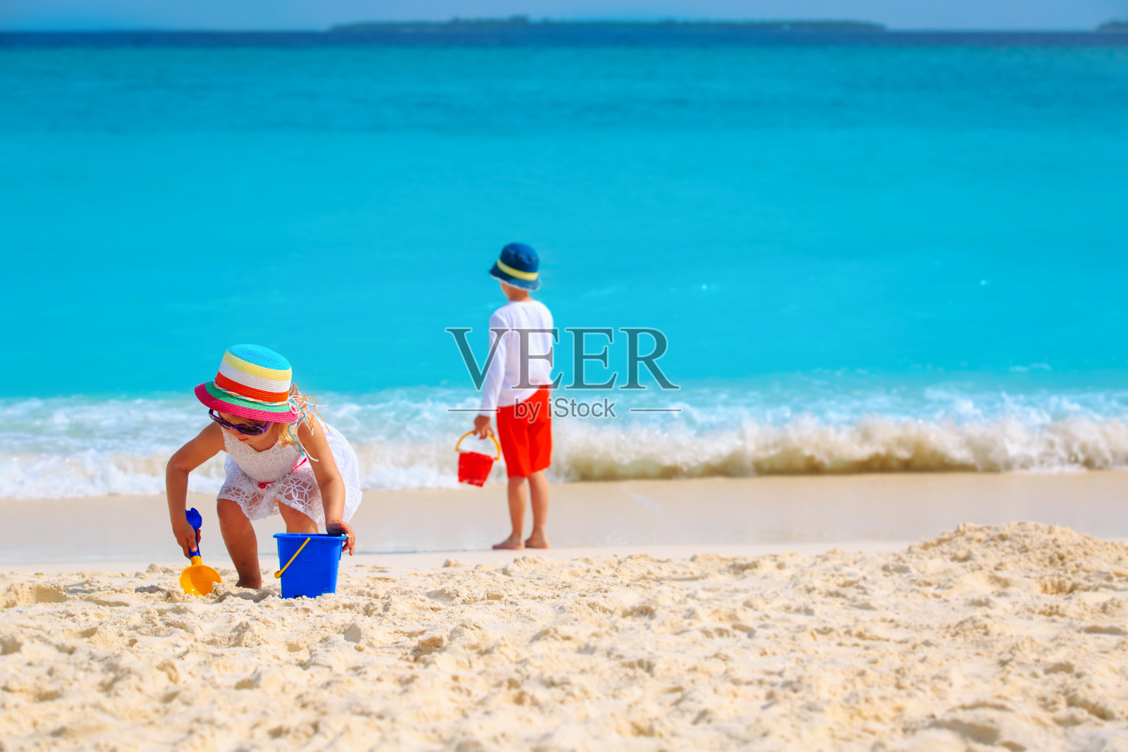 男孩和女孩在海滩度假玩沙子照片摄影图片