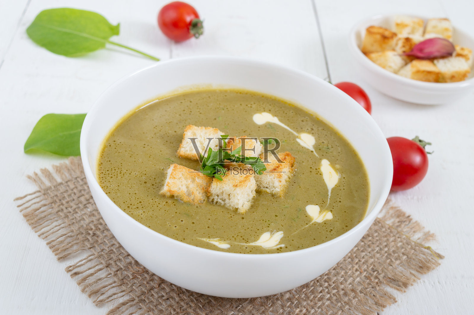 饮食汤与菠菜和油炸面包丁在一个白色的碗。适当的营养。照片摄影图片