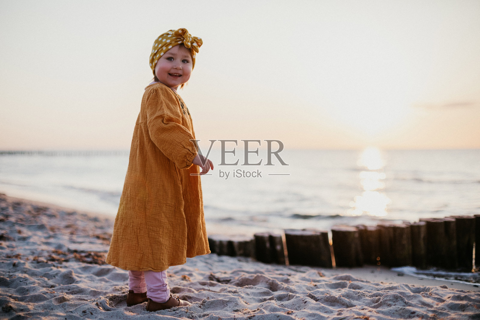 日落海滩上美丽微笑的孩子照片摄影图片