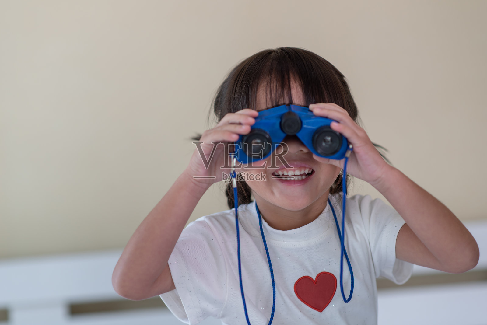 快乐的亚洲孩子喜欢通过望远镜看，旅行和冒险的孩子的概念照片摄影图片