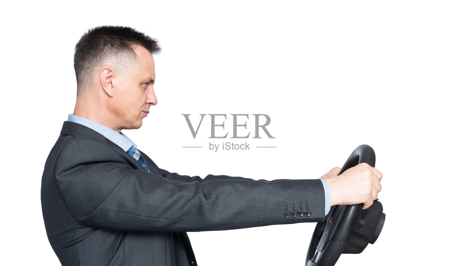 自信的成功人士穿着深色夹克手里拿着汽车方向盘，侧视图。孤立在白色背景上。汽车驱动的概念照片摄影图片