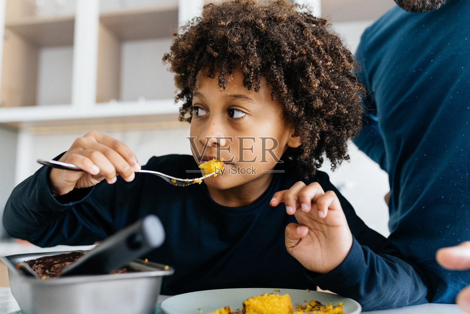 男孩在厨房吃零食照片摄影图片