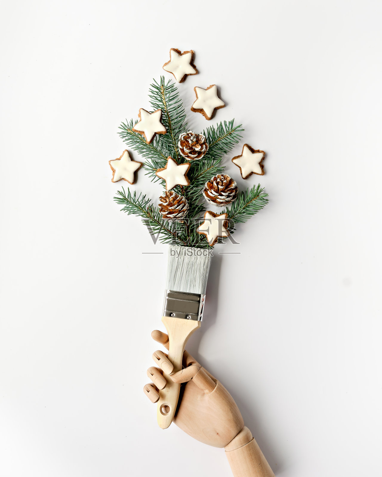 用树枝、松果装饰的天然冷杉和星形饼干装饰。创意简约简约的冬季背景。木模手握刷照片摄影图片