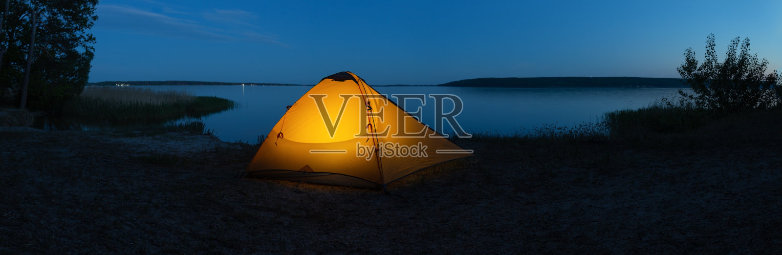 傍晚，湖上的橙色照明旅游帐篷照片摄影图片