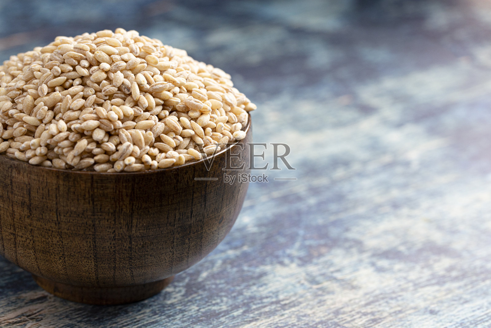 一碗大麦小麦在一个质朴的蓝色桌子上照片摄影图片