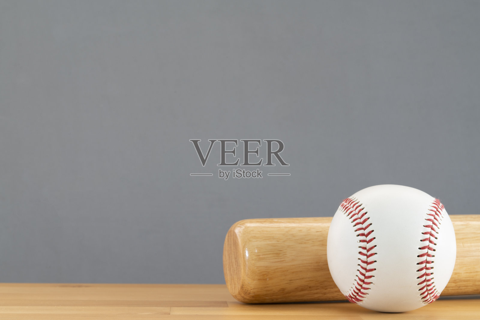 近距离棒球和棒球棒在木制桌子上与灰色拷贝空间背景，运动概念照片摄影图片