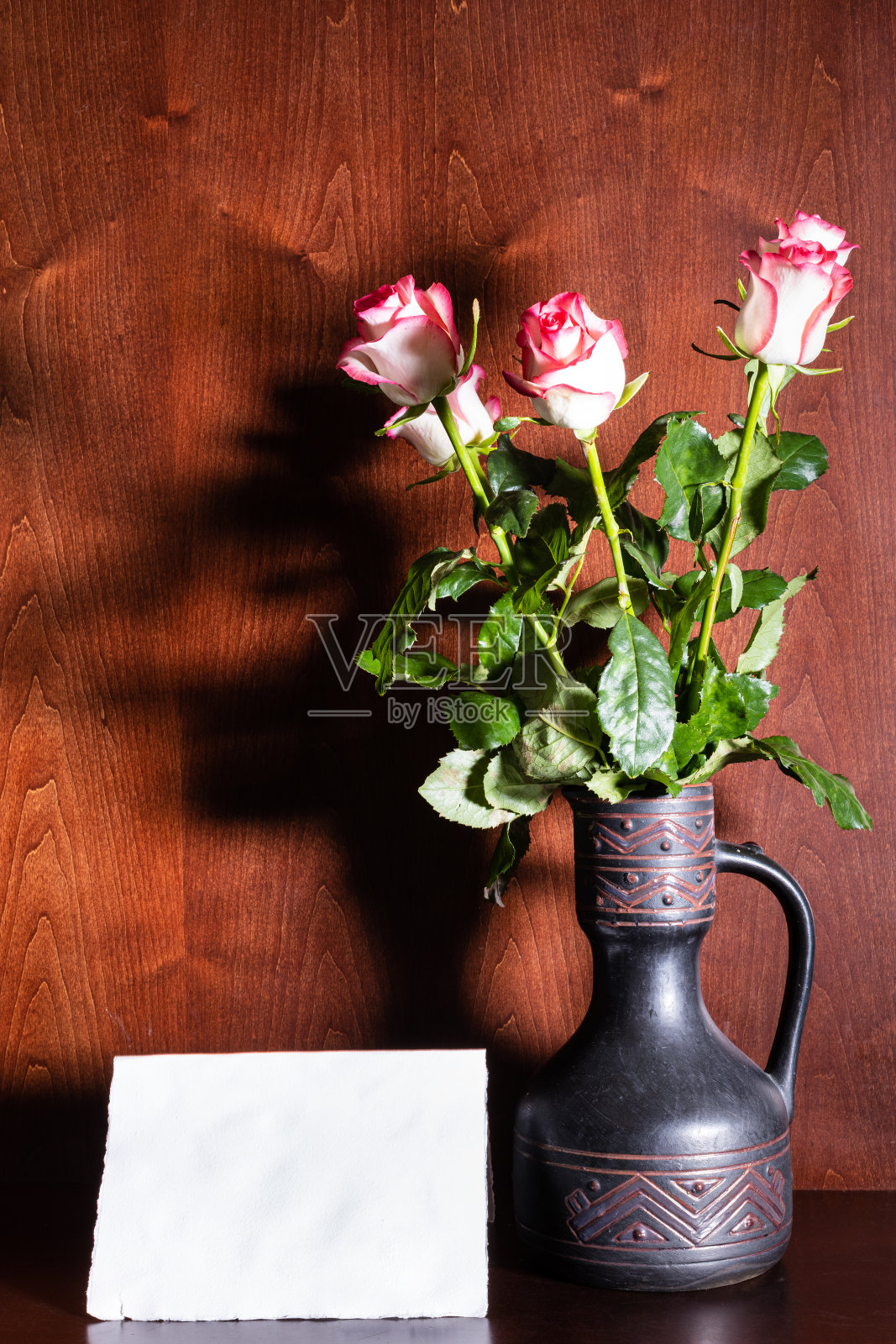 空白的纸和粉红色的玫瑰在陶瓷罐照片摄影图片