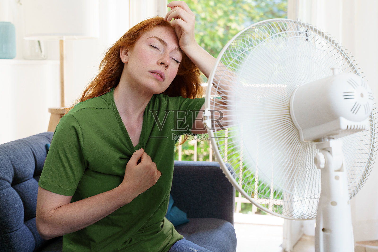 一名妇女在家里忍受酷暑照片摄影图片