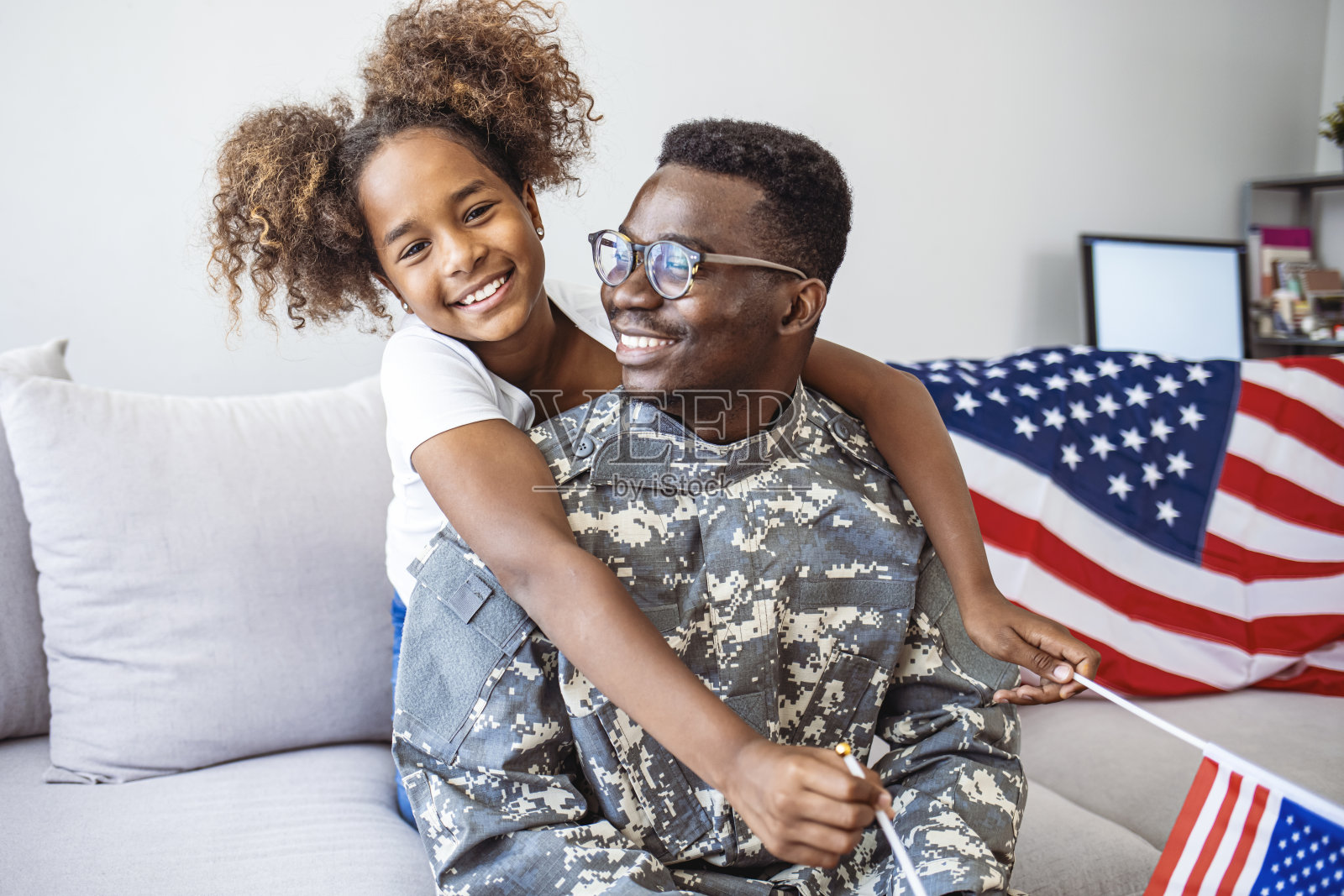 幸福的美国家庭父亲穿着军装和可爱的小女孩女儿拿着美国国旗的肖像照片摄影图片