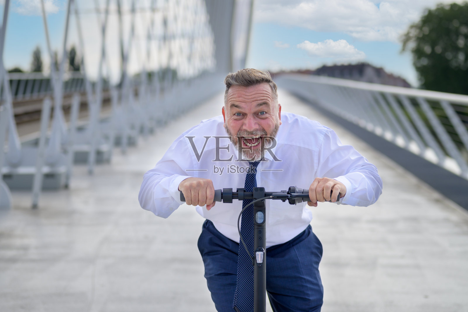 一个欢声笑语的人骑着电动摩托车疾驰而过照片摄影图片