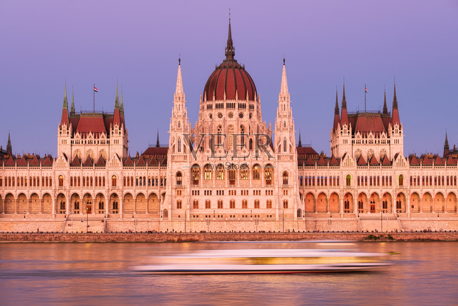 布达佩斯,匈牙利。历史悠久的议会大厦的经典景象。多瑙河和日落时的议会。在多瑙河上的轮渡旅行照片摄影图片