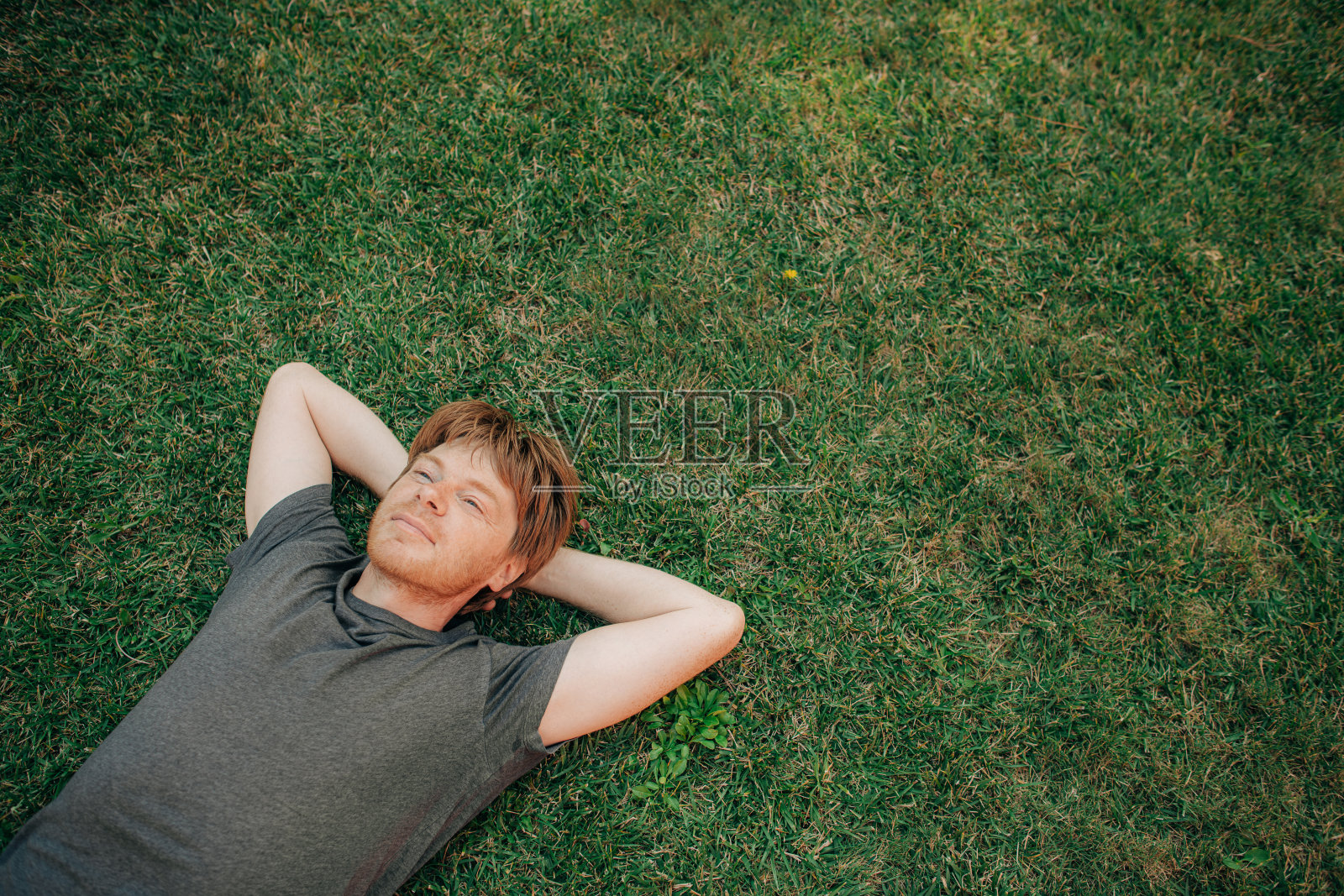 安详的中年男子躺在草地上的画像照片摄影图片