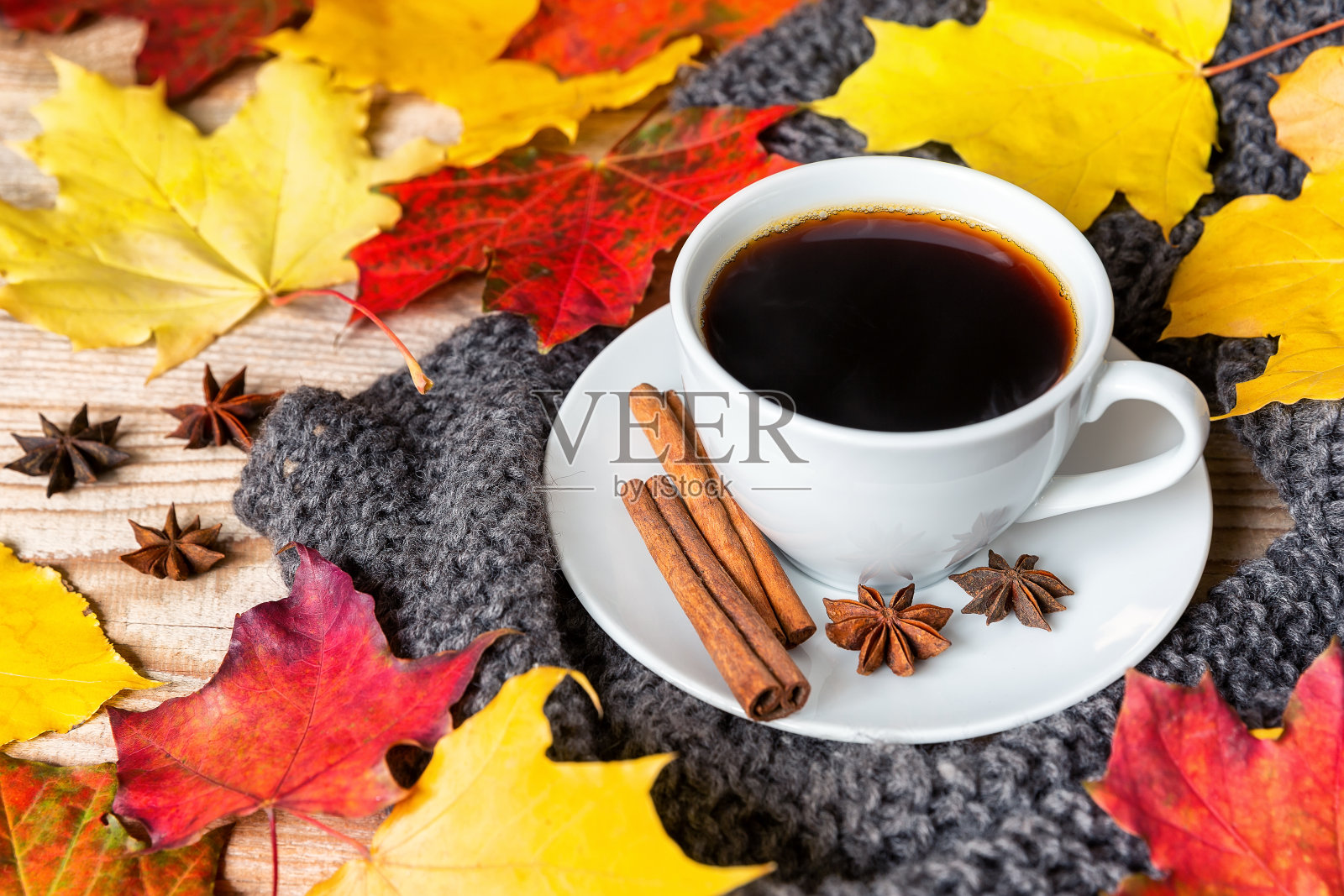 舒适的秋天早晨与咖啡肉桂，八角，舒适的毛衣和秋天的叶子木制背景。照片摄影图片