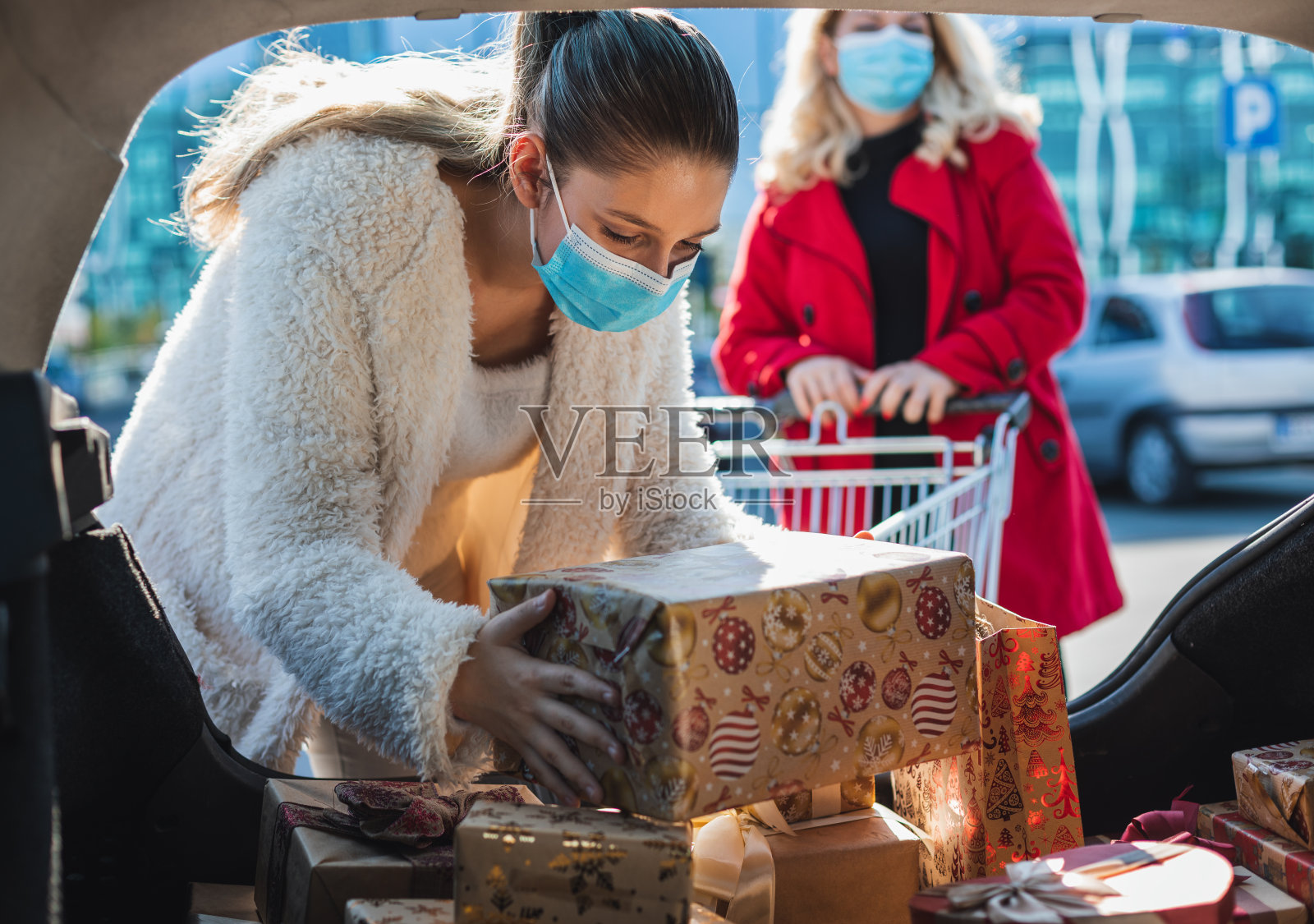 家庭购物圣诞礼物，他们戴着防护口罩，以保护免受冠状病毒COVID-19。照片摄影图片