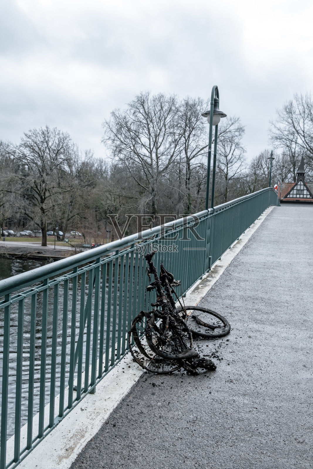 破旧的自行车报废了。躺在水。桥照片摄影图片