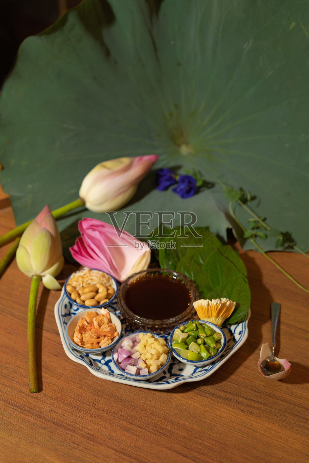 一套Miang kham，泰国开胃菜与荷花和叶子包裹在传统陶瓷盘。照片摄影图片