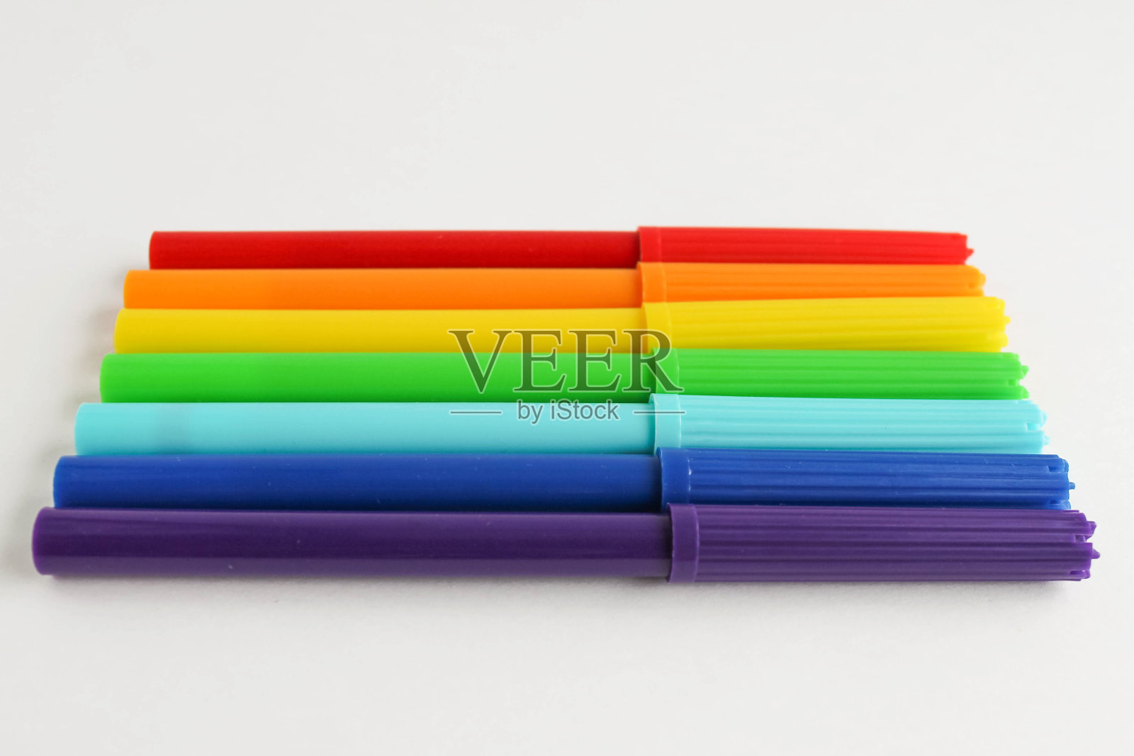 五颜六色的记号笔按彩虹的顺序放在一张白纸上照片摄影图片