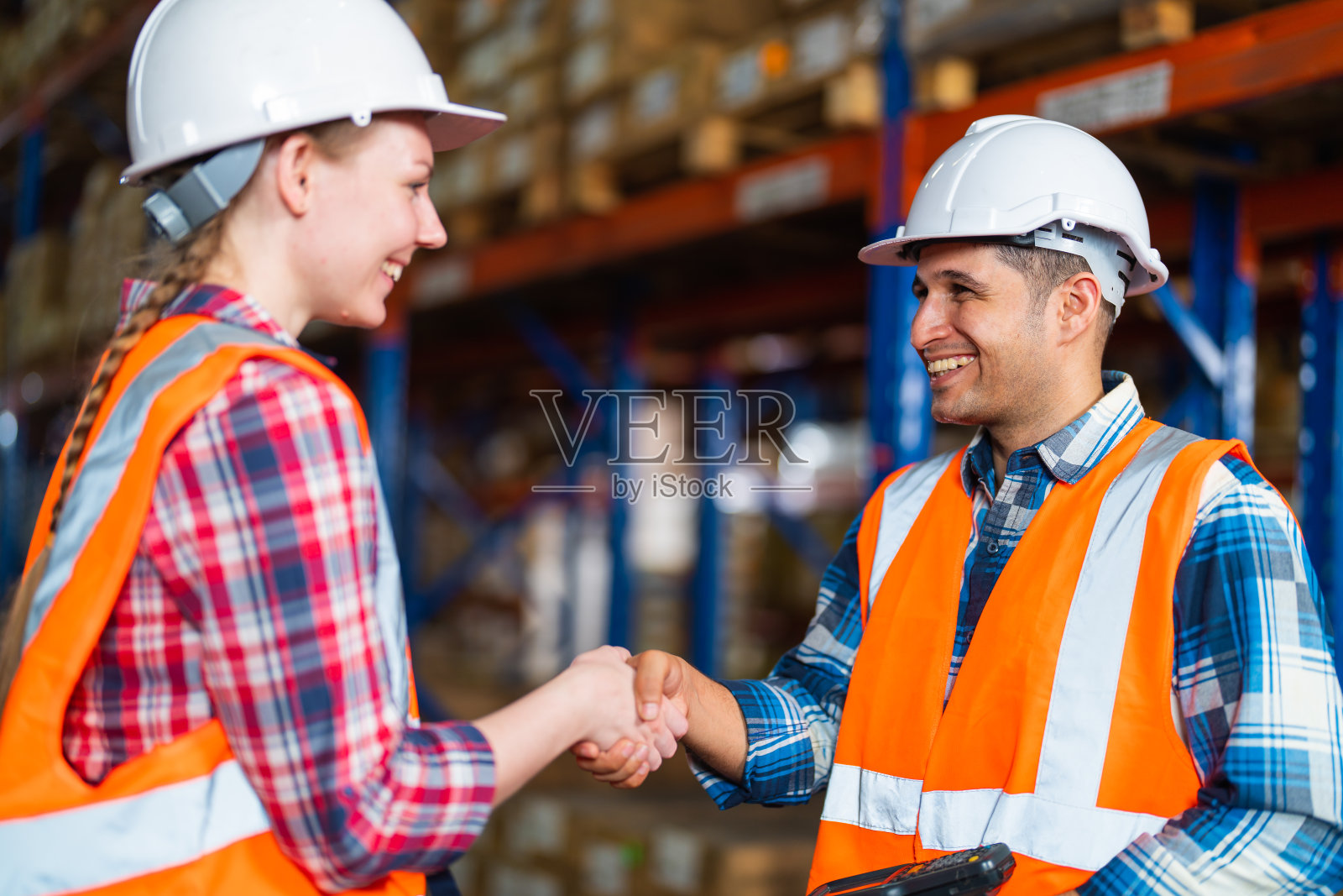两个仓库工作人员在成功项目或第一次在配送中心仓库打招呼时握手。照片摄影图片