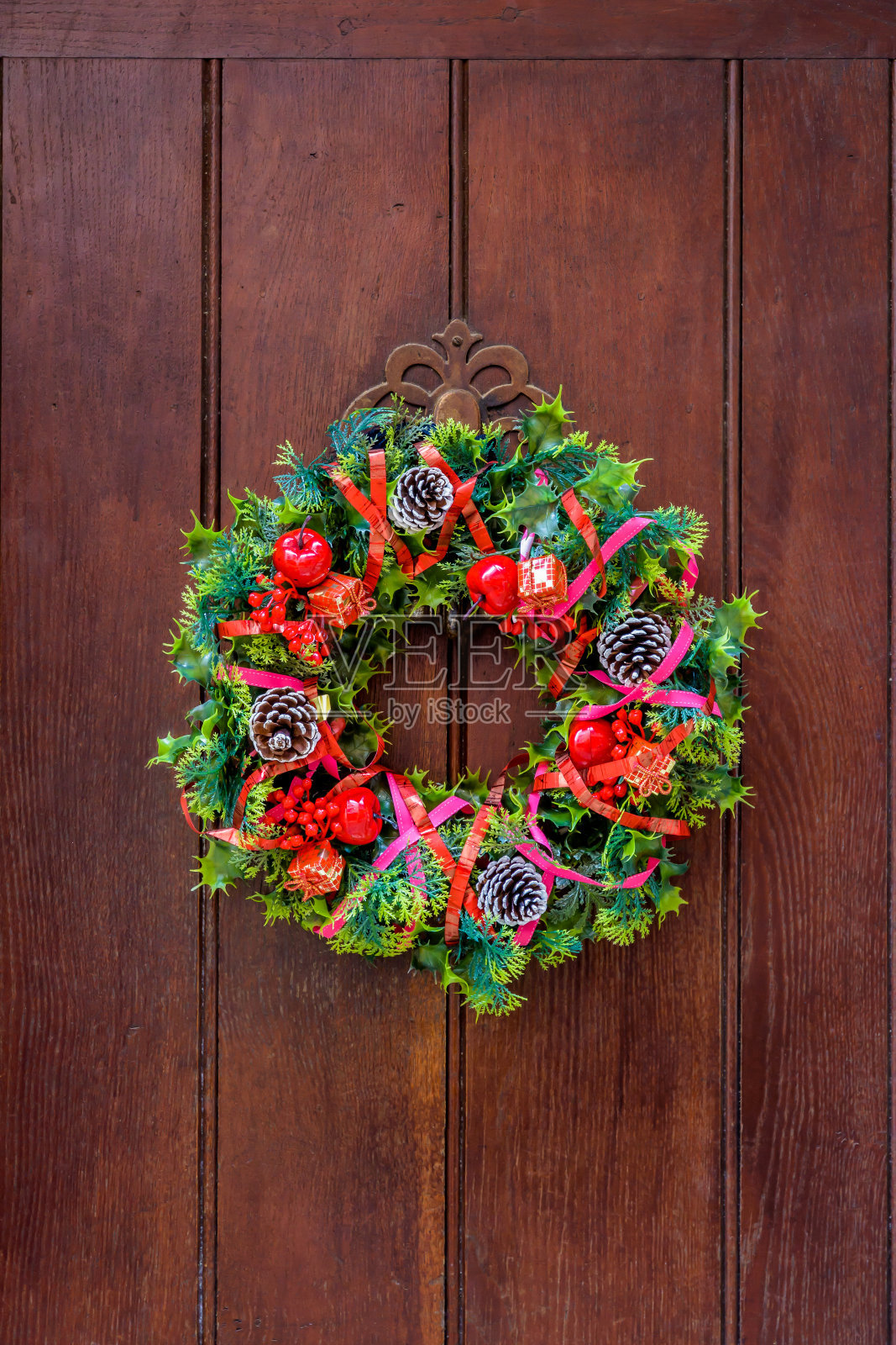 挂在旧木门上的圣诞花冠。照片摄影图片