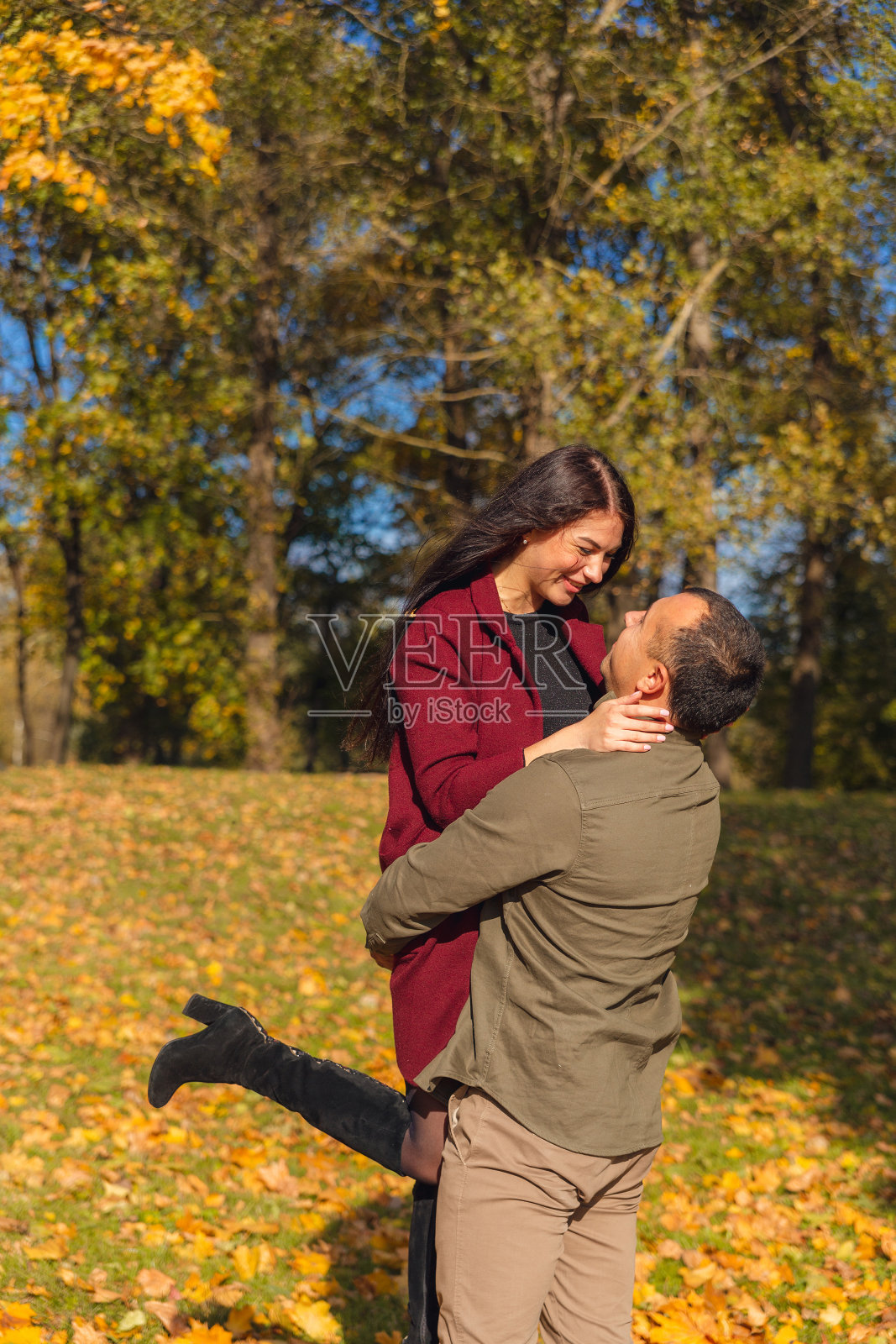 这对可爱的夫妇在大自然中一起玩耍。男朋友把女朋友抱在怀里。照片摄影图片