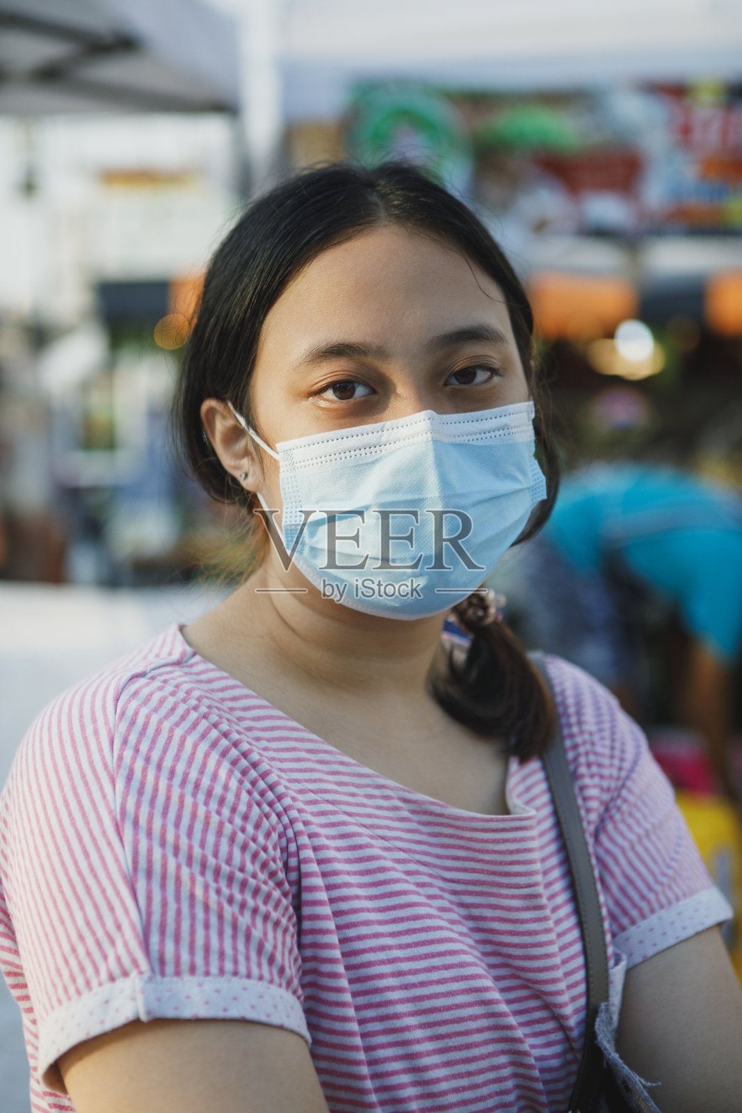 亚洲年轻女性戴着防护口罩站在室外照片摄影图片