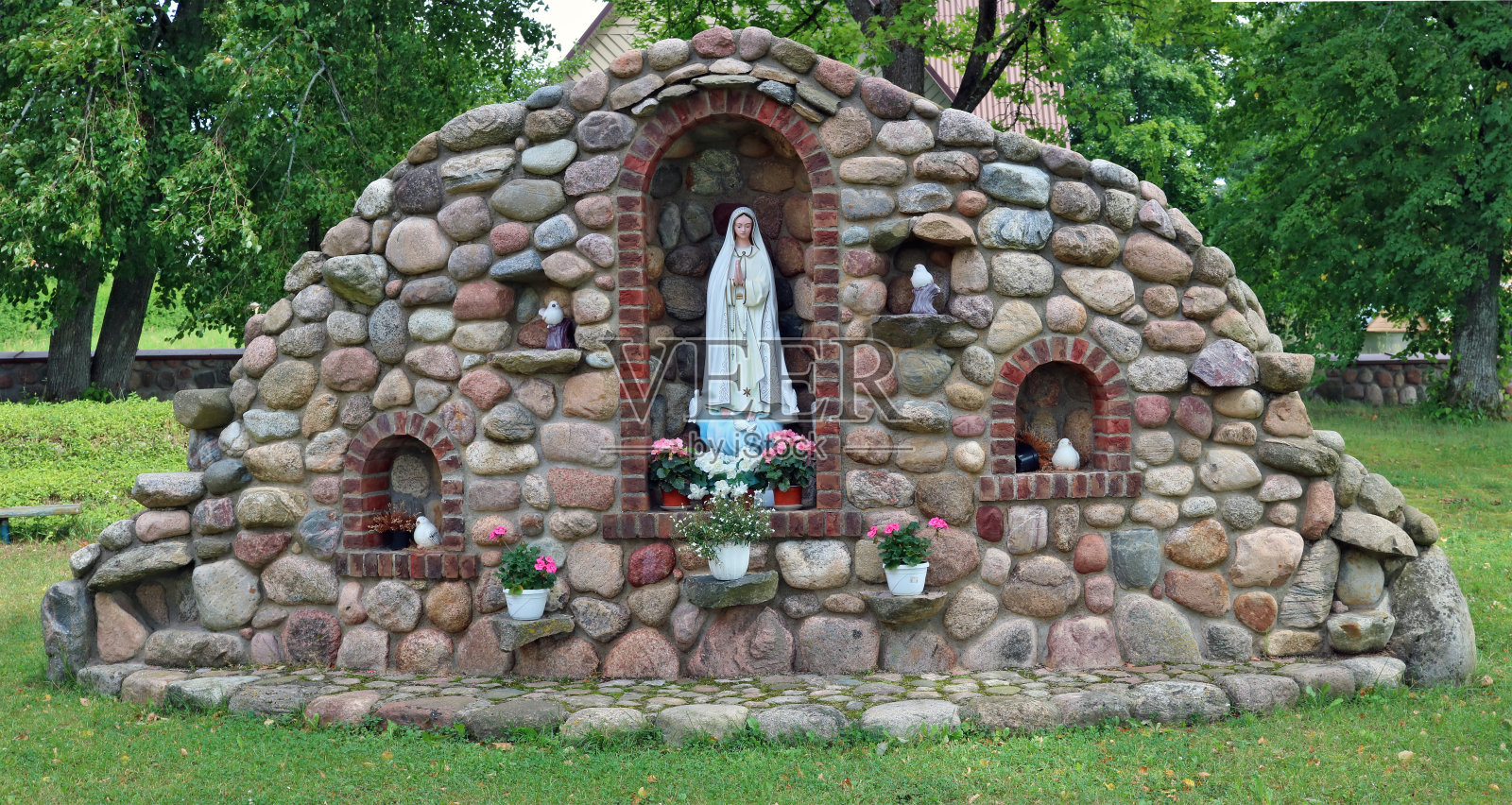 在乡村天主教教堂附近的圣母玛利亚纪念碑照片摄影图片