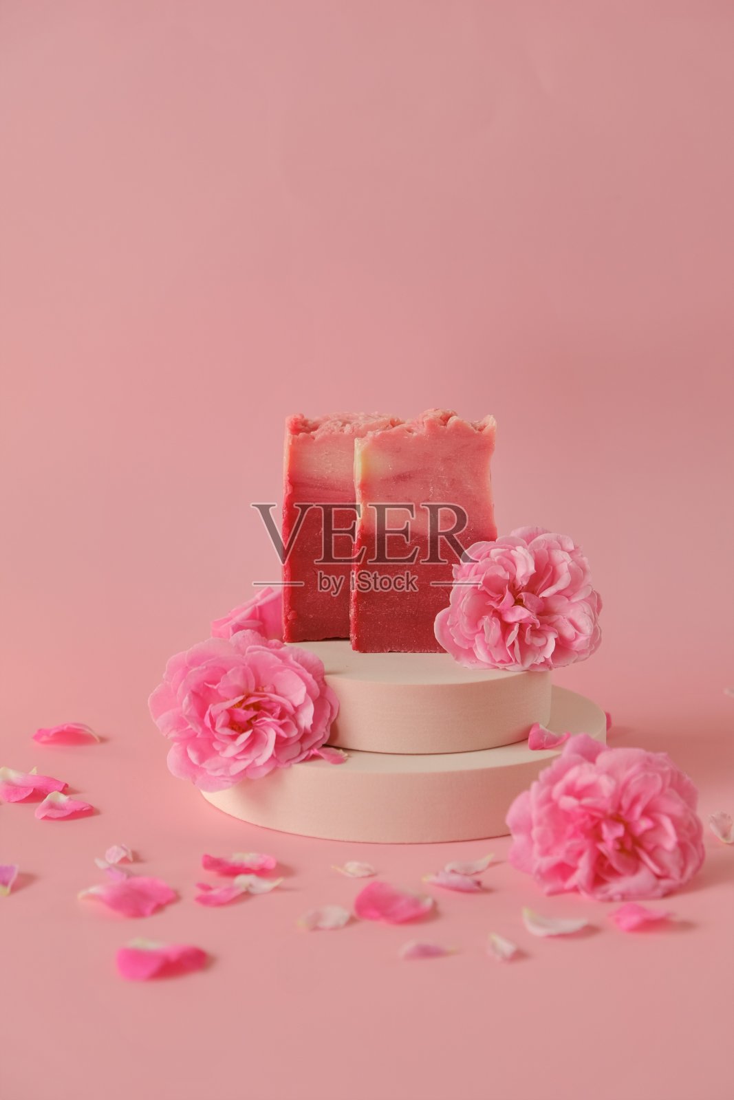 玫瑰皂。美丽和芳香疗法。花肥皂。粉红色的肥皂条和粉红色的玫瑰在讲台上粉红色的背景照片摄影图片
