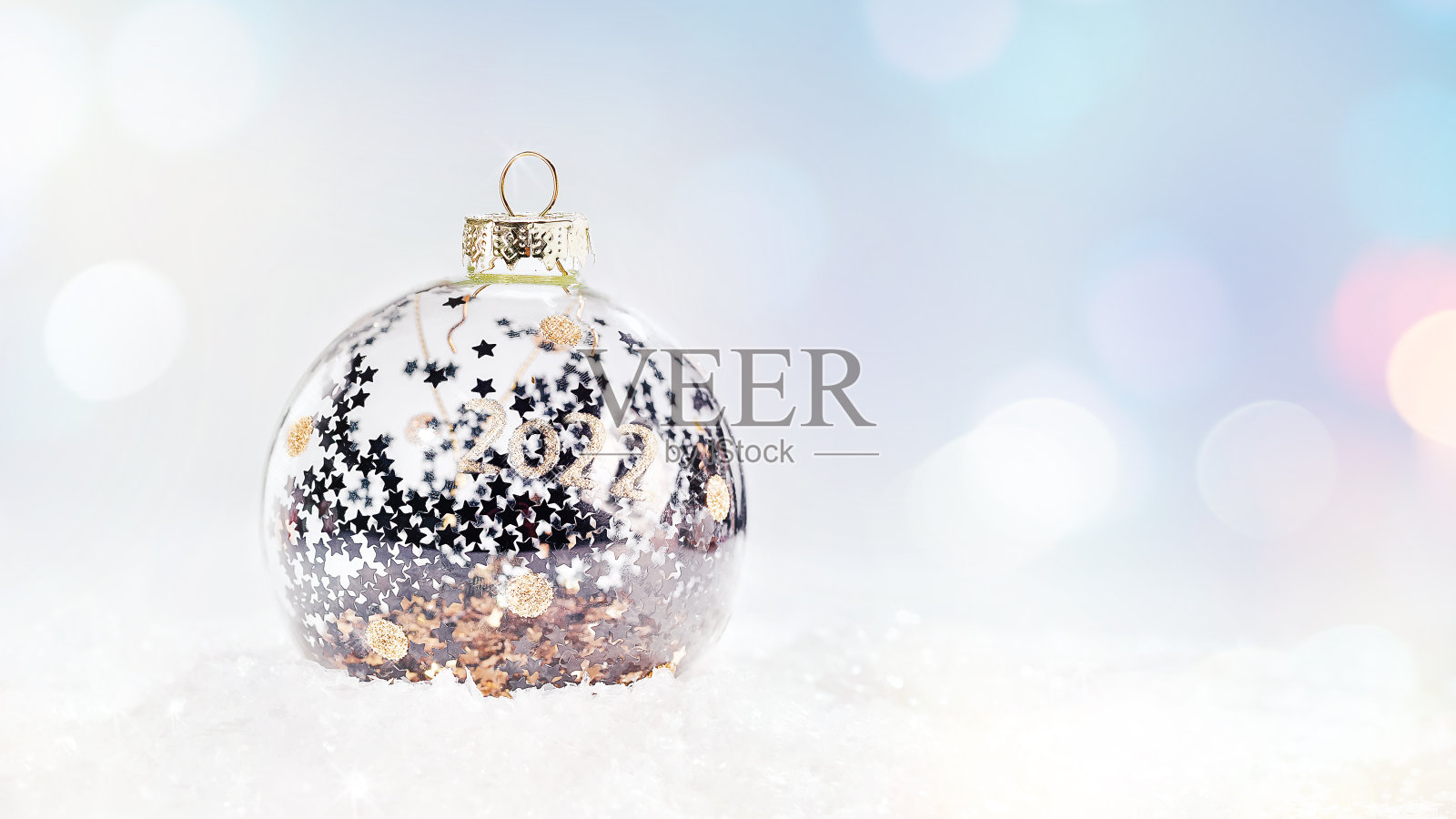 闪亮的，银色的玻璃圣诞球在雪在一个淡淡的背景。闪闪发光,闪亮的背景。圣诞节、冬天、新年的概念。副本的空间。冬天的背景。圣诞和新年放假，散宴，淡定。照片摄影图片